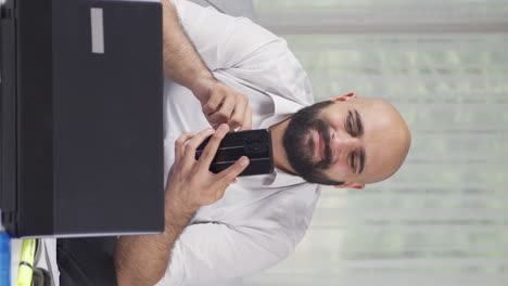 vertical video of home office worker man having problems and stress on the phone.