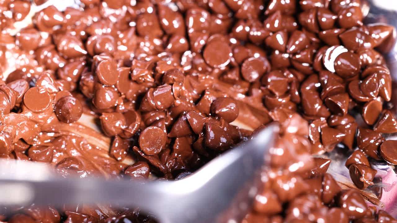 Spoon stirring chocolate chips in a bowl