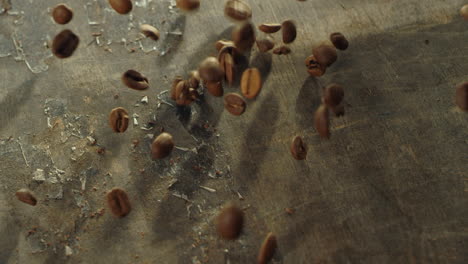 los granos de café caen sobre la superficie de la mesa en cámara lenta. ingredientes de la bebida aromática