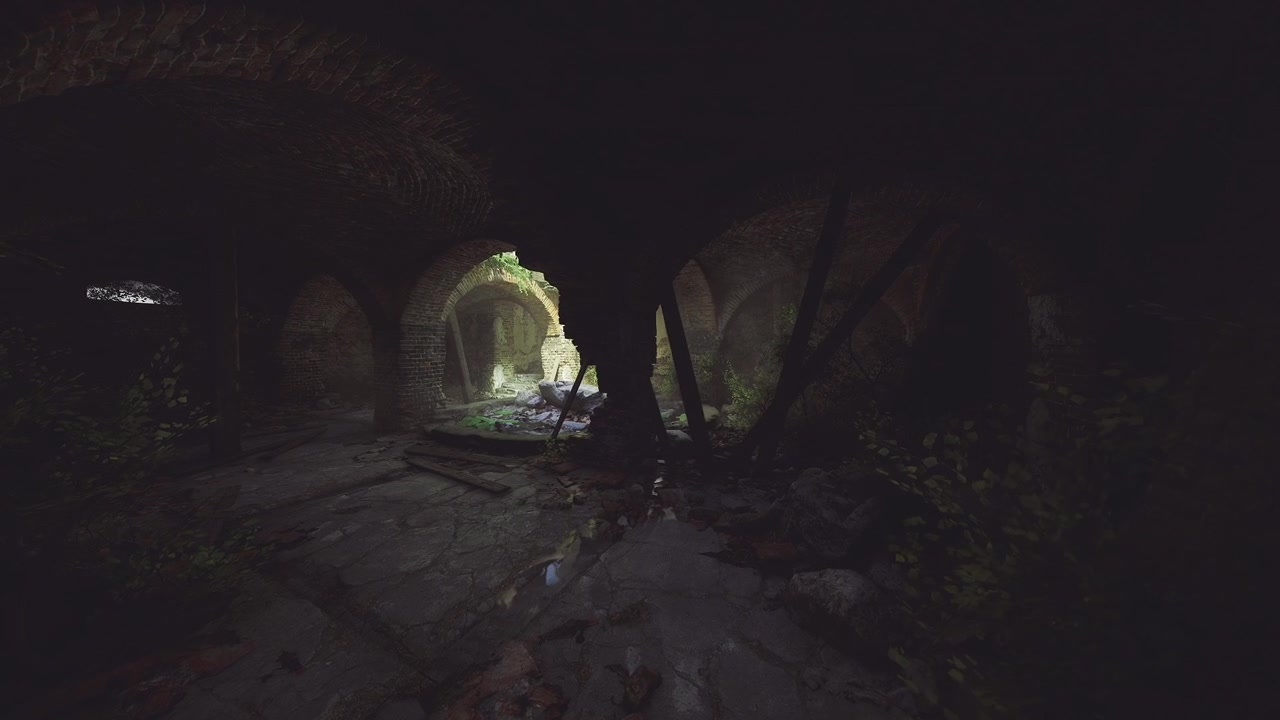 L'ingresso di una grotta illuminato dal sole mostra un arco in pietra antico con muschio e ombre