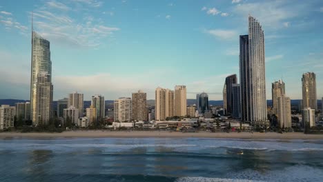 Parallel-aerial-of-Surfers-Paradise-skyline-from-over-the-ocean,-Gold-Coast,-Queensland,-Australia-20230502