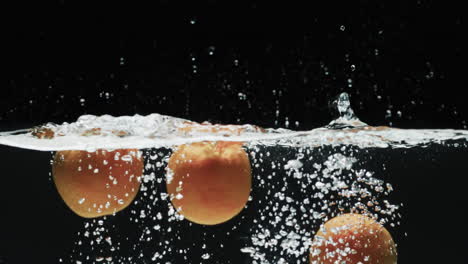 video de tres naranjas bajo el agua con espacio de copia sobre fondo negro
