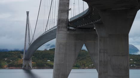 massive concrete supports of the halogaland bridge tower above the calm waters of the fjord