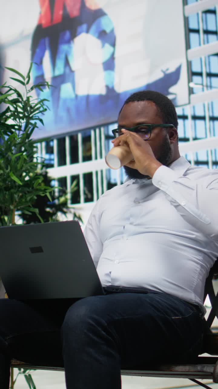 Vertical Video Adult man siting comfortably on a bench navigating a website on his laptop