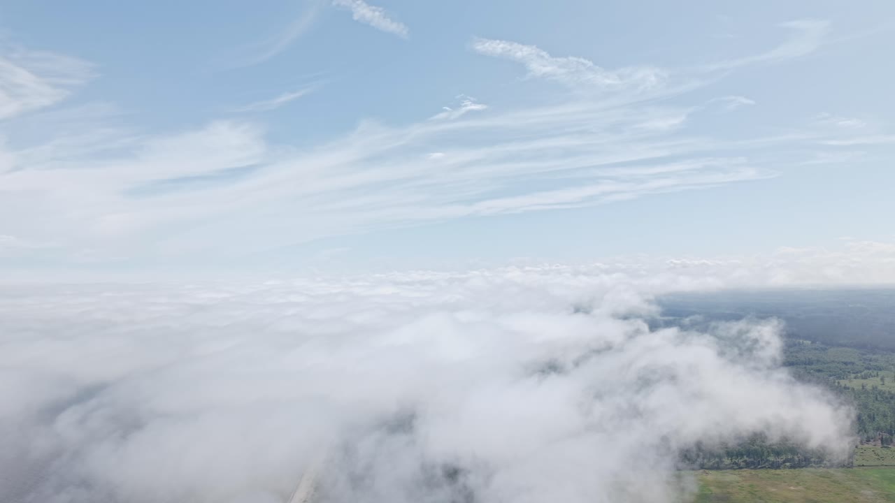 Aerial sky views above low cloud formations drifting over landscape