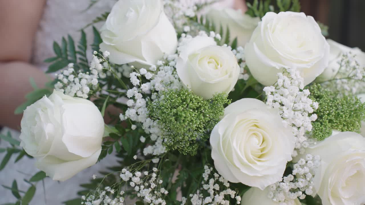 Brud holder smuk buket af hvide blomster