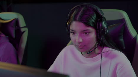 young female gamer playing video games in a gaming club