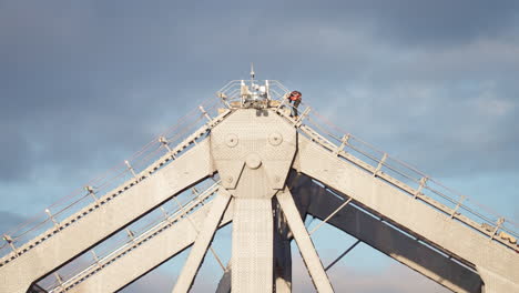 fireworks technician climbing top of story bridge arch in brisbane, 4k slow motion