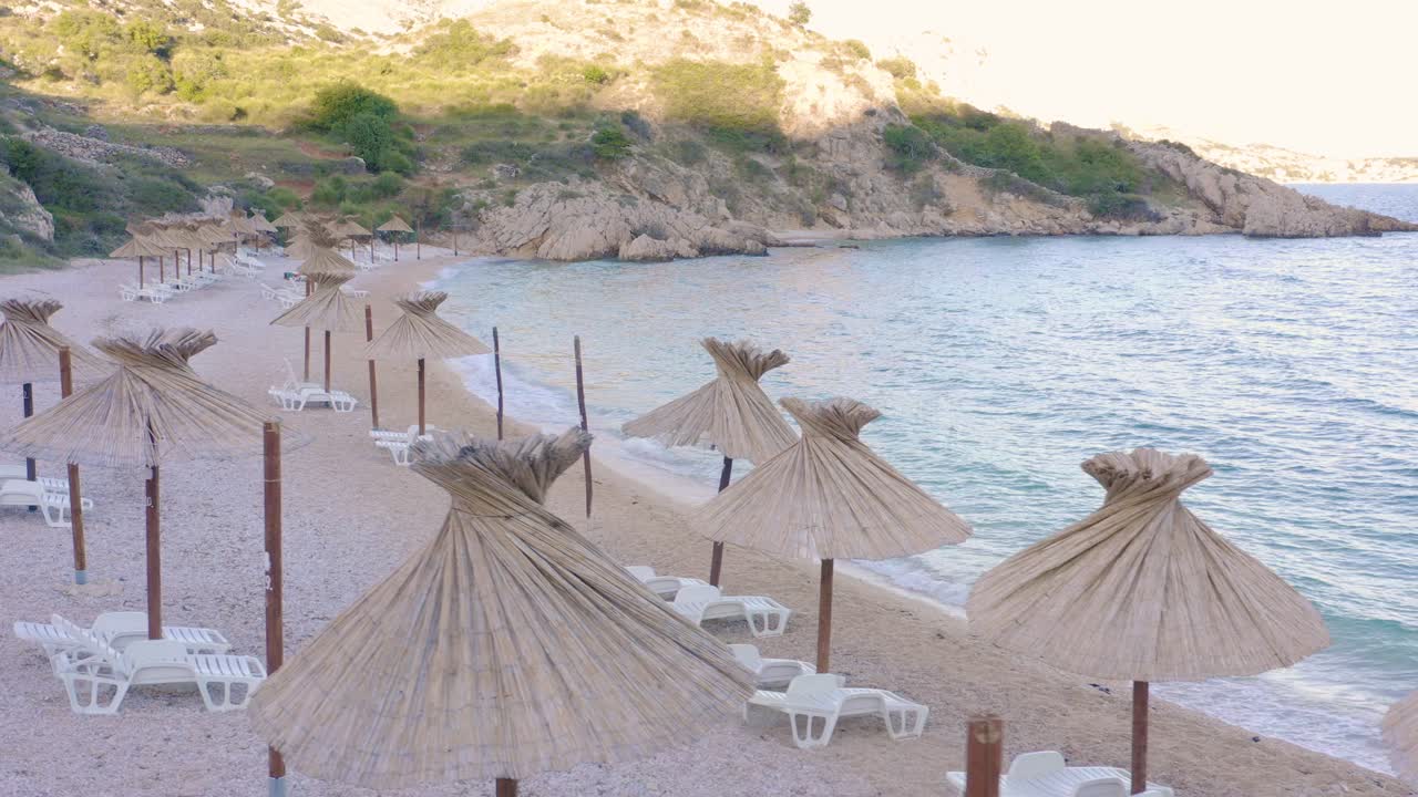 Parasols And White Sun Loungers In A Lovely Beach In Krk Island, Croatia - Perfect Summer Destination - drone shot