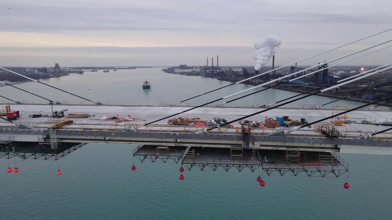 Close-up of Gordie Howe Bridge deck under construction above calm river in Detroit, USA