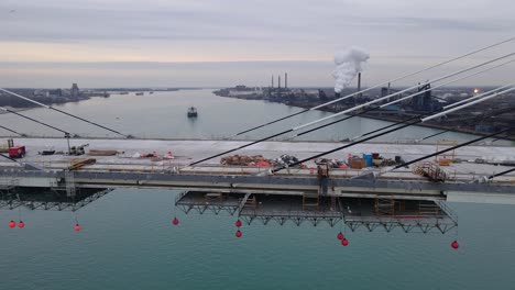 close-up of gordie howe bridge deck under construction above calm river in detroit, usa