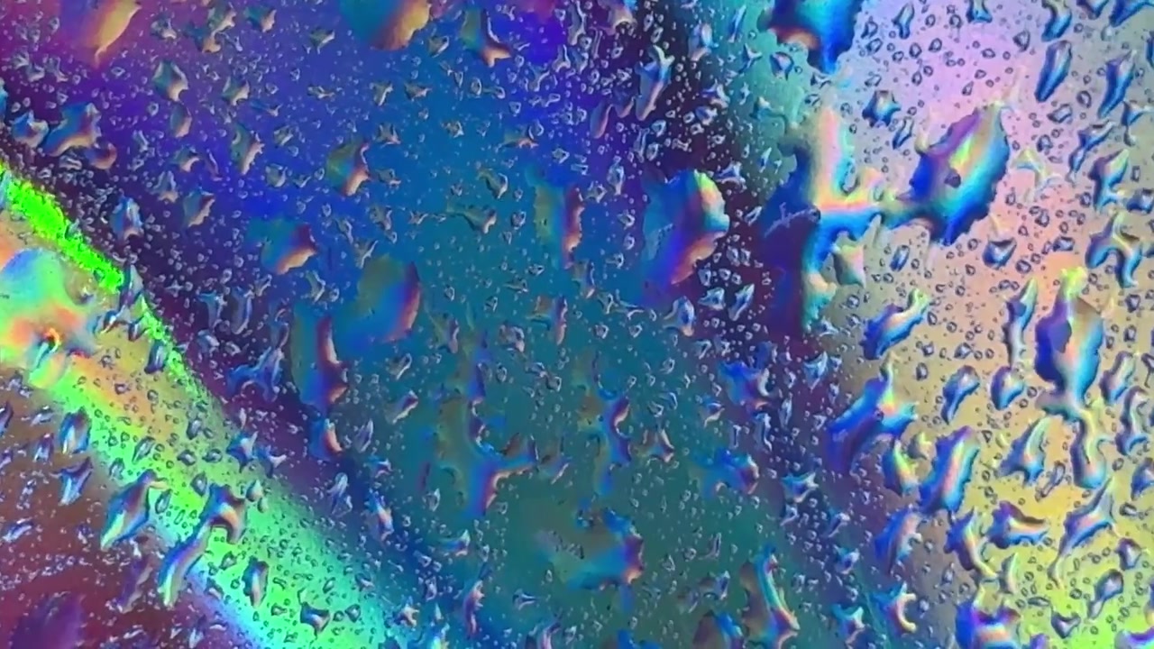Raindrops on Glass with Vibrant Iridescent Background