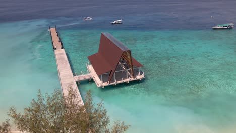 Hermosa-Toma-De-Muelle-En-Gili-Meno-Con-Botes-De-Estacionamiento-Y-Agua-Clara-Durante-El-Día-Soleado