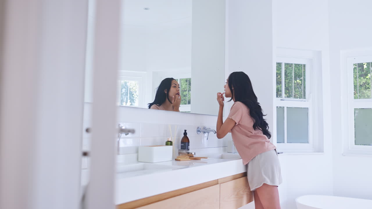 espejo, baño y aplicación de labios de la mujer