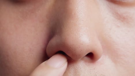 close up of a young man picking nose with finger