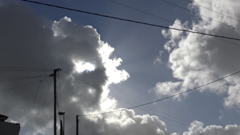 blue sky with some clouds passing by the sun