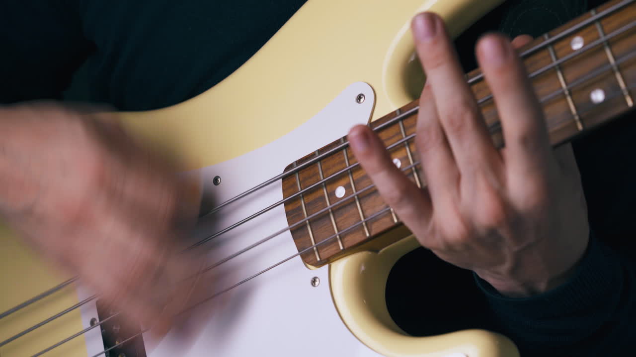 las manos del artista funky tocan solo en la guitarra bajo con trucos