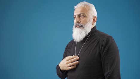 christian man making the sign of the cross representing the father, son and holy spirit.