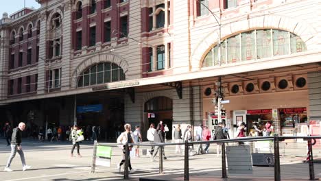 people crossing street near historic station