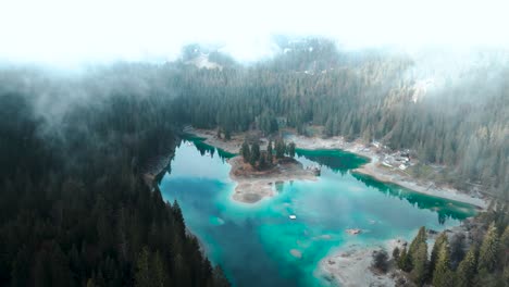 vista aérea de un prístino lago de agua azul caumasee con bosques y nubes alrededor en suiza