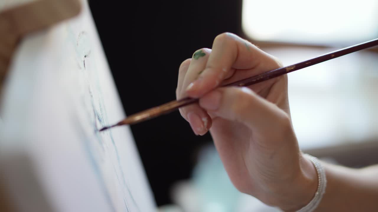 화면을 사용하여 미술 스튜디오에서 캔버스에 그림을 그리는 여성 예술가