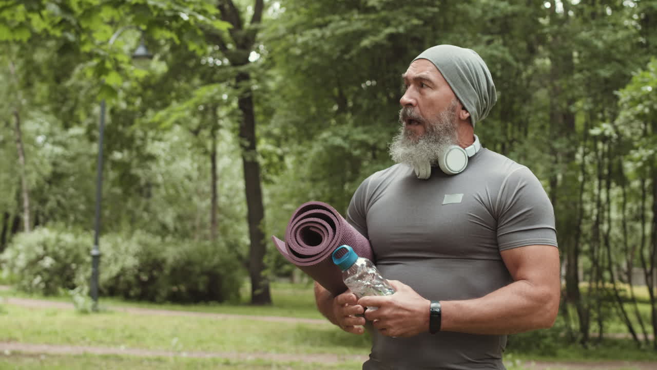 Senior Man Outdoors with Yoga Mat and Water Bottle
