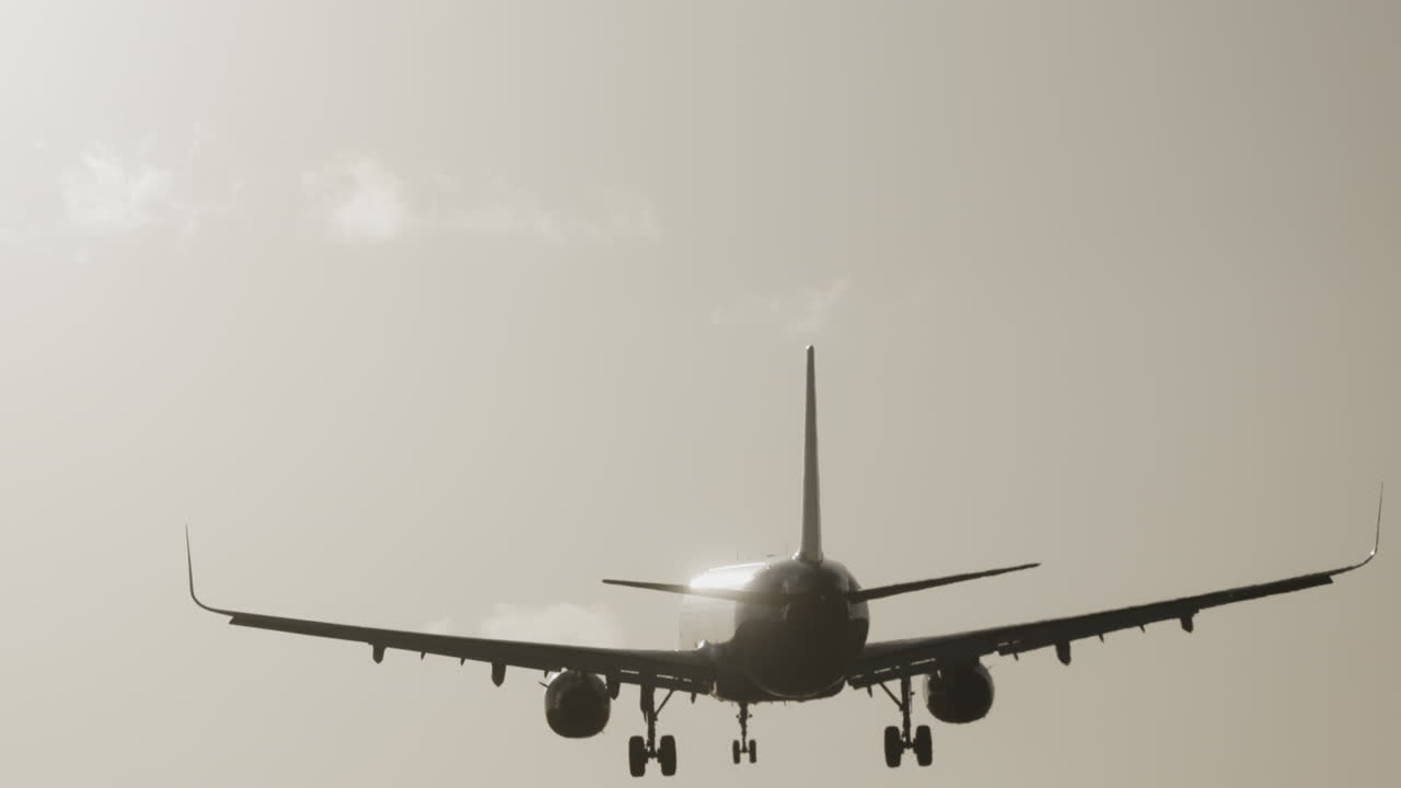 Avión volando en el cielo para aterrizar en el aeropuerto a cámara superlenta al atardecer