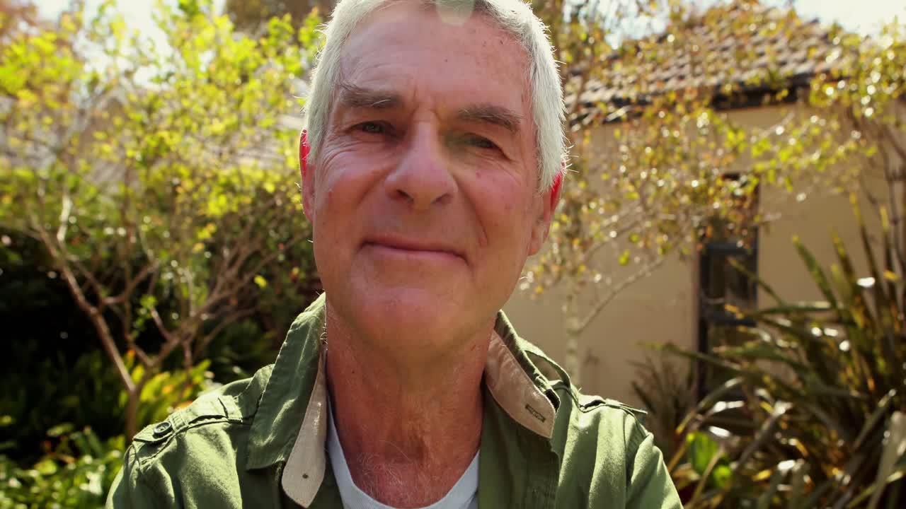 retrato de un hombre mayor de pie con los brazos cruzados 4k