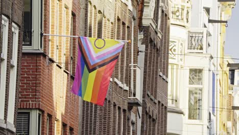 Colorful-New-Progress-Pride-Flag-hanging-on-the-side-of-a-house-in-Amsterdam