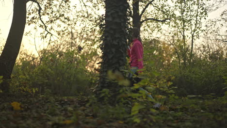 mujer caminando por un bosque al atardecer