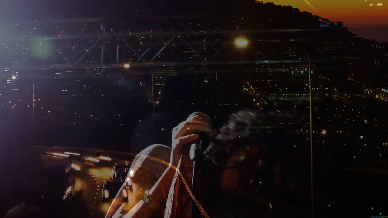 Woman singing into mic on rooftop at dusk, showing technology data overlays and city light graphs