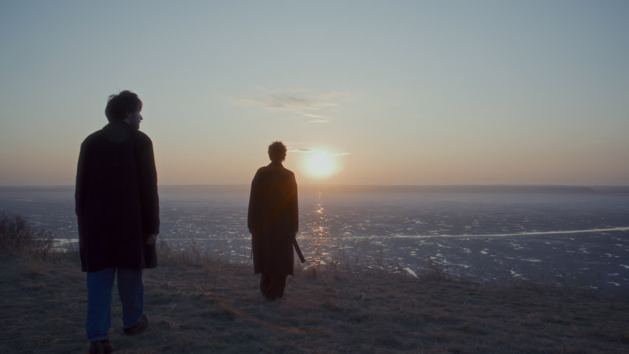 Couple Walking to Frozen Lake, Holding Hands and Watching Sunset