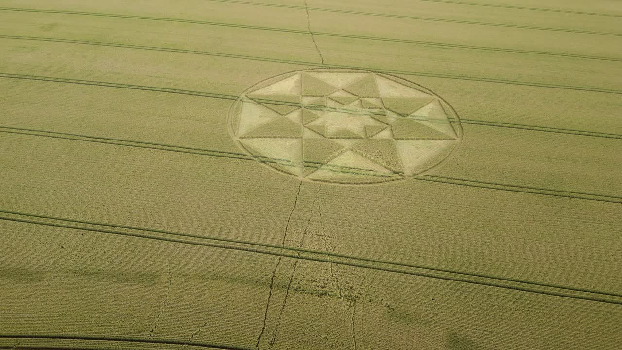 vista aérea ascendente para revelar el patrón simétrico de círculos estelares en el campo de trigo de golden hampshire, 2023