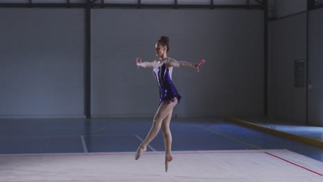 Teenage-female-gymnast-performing-at-sports-hall