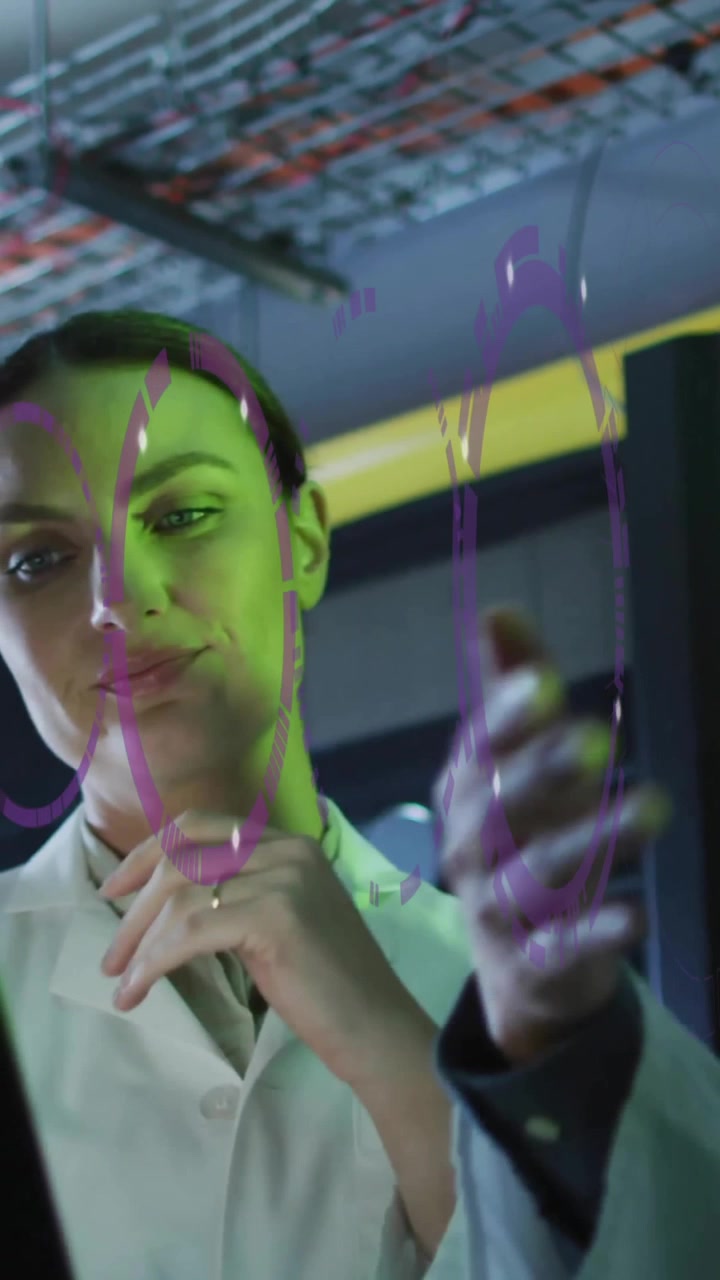 Vědci v laboratorních pláštích diskutují data na notebooku se zeleným osvětlením.