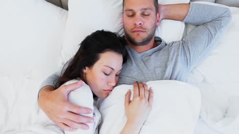 couple sleeping peacefully on bed 4k