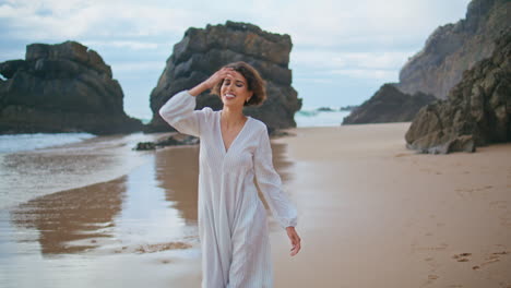 happy girl strolling ocean shore alone. smiling woman having fun resting rocky