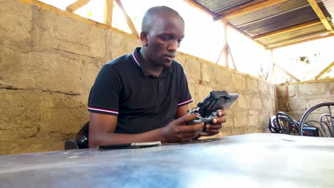 an african drone pilot flying drone in rural africa