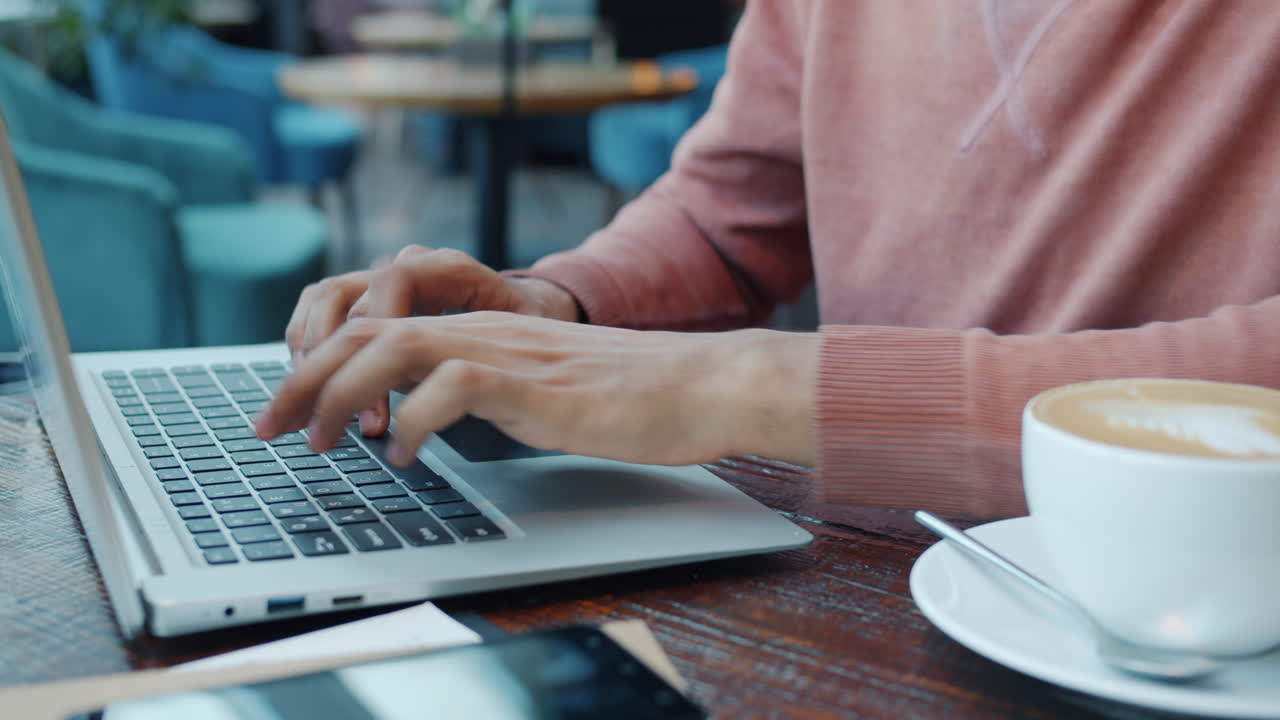 persona trabajando en una computadora portátil en un café