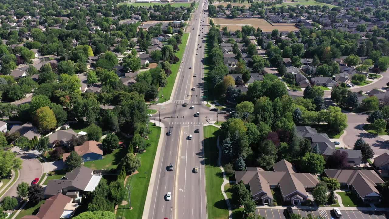 Drone pushes in and tilts up over a road with traffic.