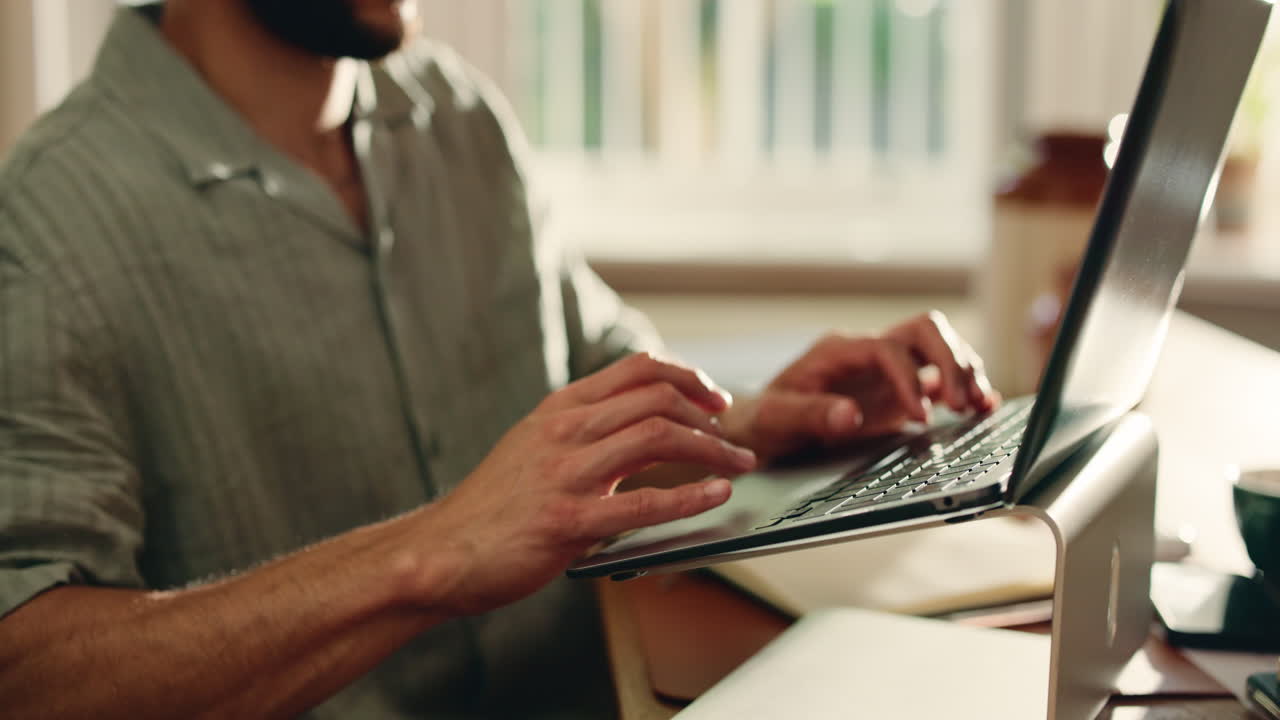 Close-up of Man's Hands Typing on Laptop Keyboard