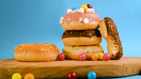 steady shot of a pile of donuts with falling gumballs