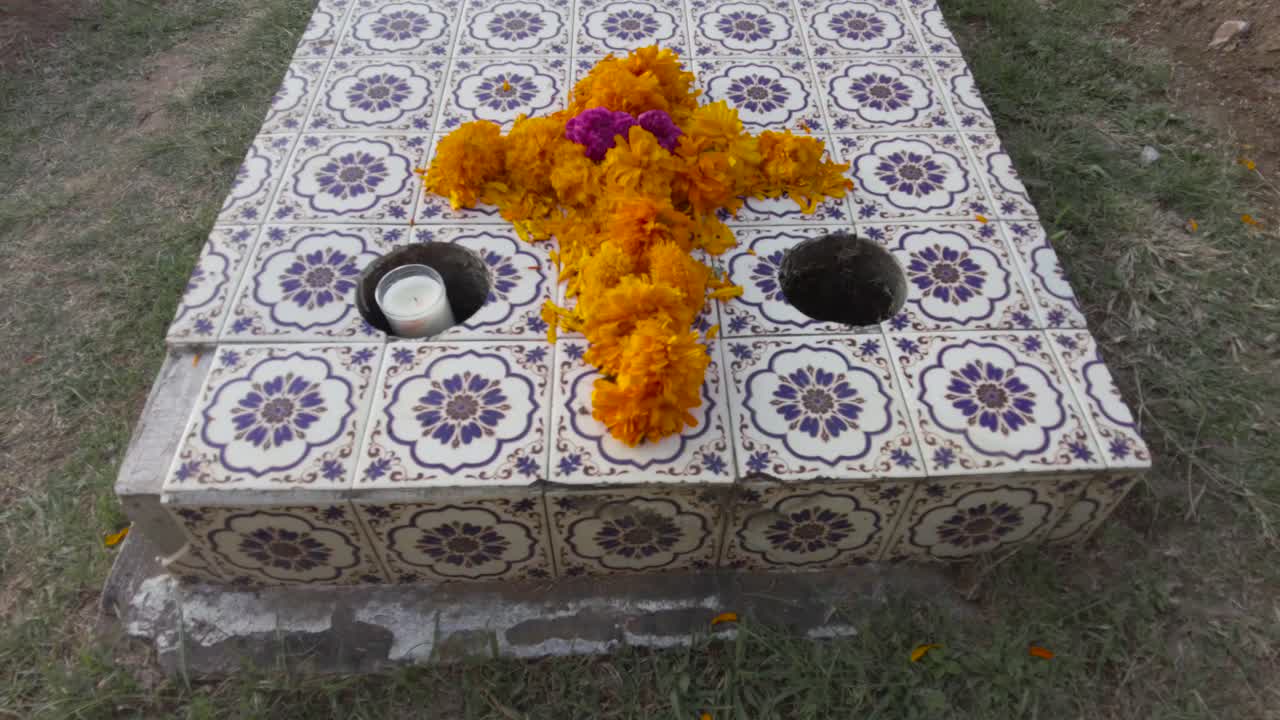 Tilt up shot of a tomb adorned with cempasuchil marigold flowers for the celebration of the day of the dead at a graveyard in Mexico Puebla Cholula