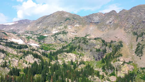 Aerial-Drone-Footage-of-Scenic-Mountain-Peak-next-to-Pine-Tree-Forest-near-Clear-Blue-Lake-Water-in-Nederland-Colorado-during-Summer-in-the-Rocky-Mountains