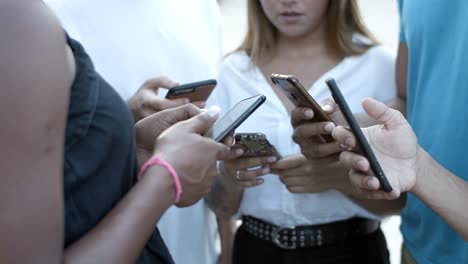 Cropped-shot-of-young-people-using-smartphones