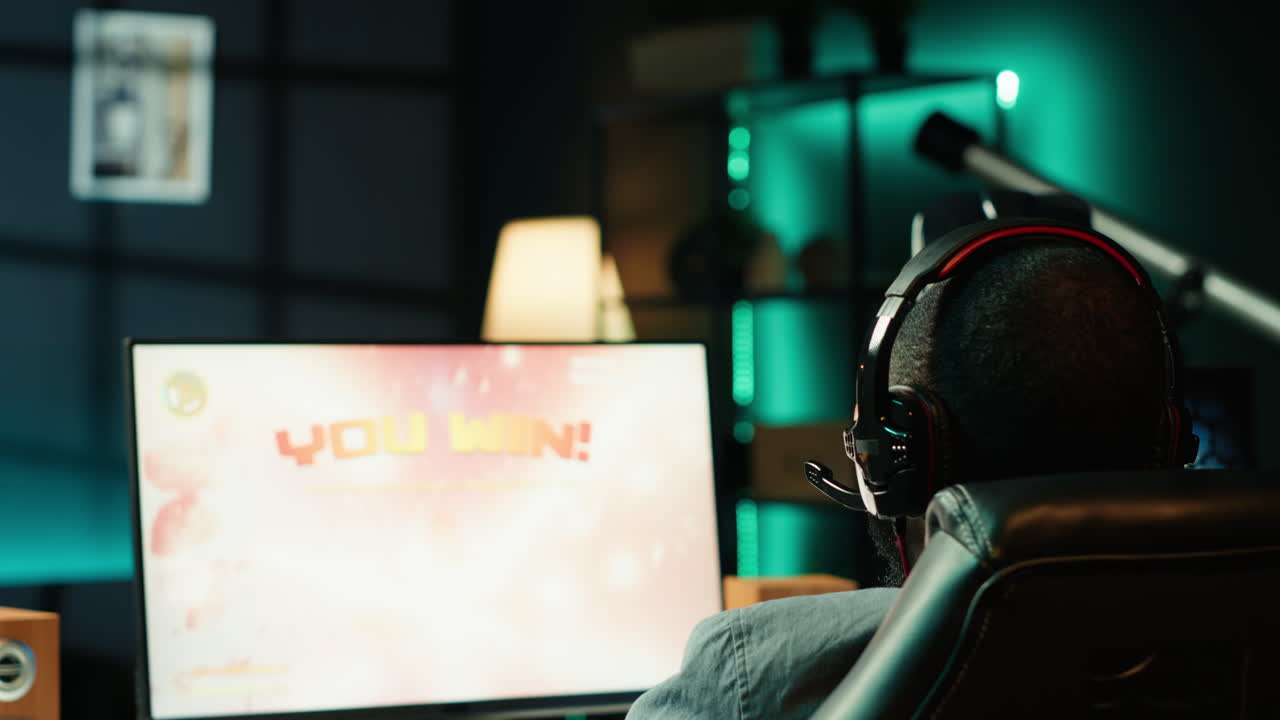 기쁜 게이머가 sf 게임을 이긴 후 흥분해서 공중으로 주먹을 던지고 있습니다.