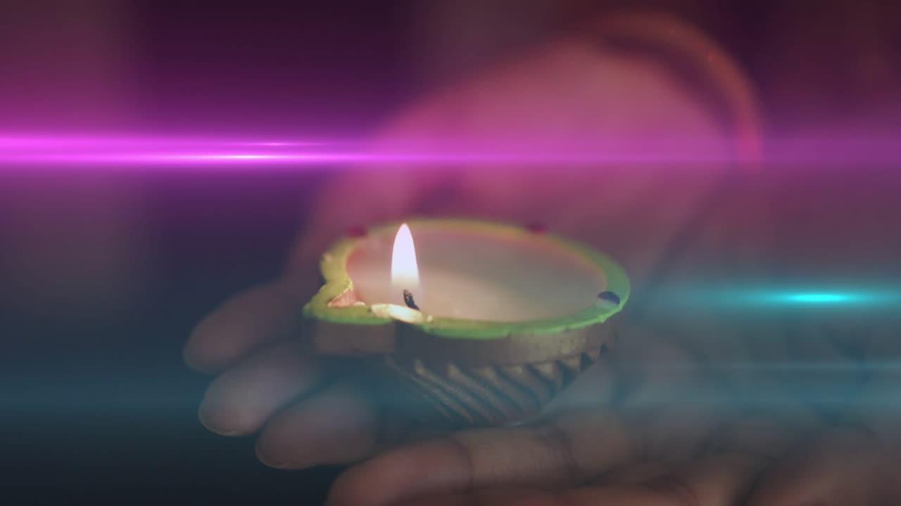 Donna che tiene in mano un diya acceso, la mano si muove facendo tremolare la fiamma per il rituale con sovrapposizioni di striature di colore