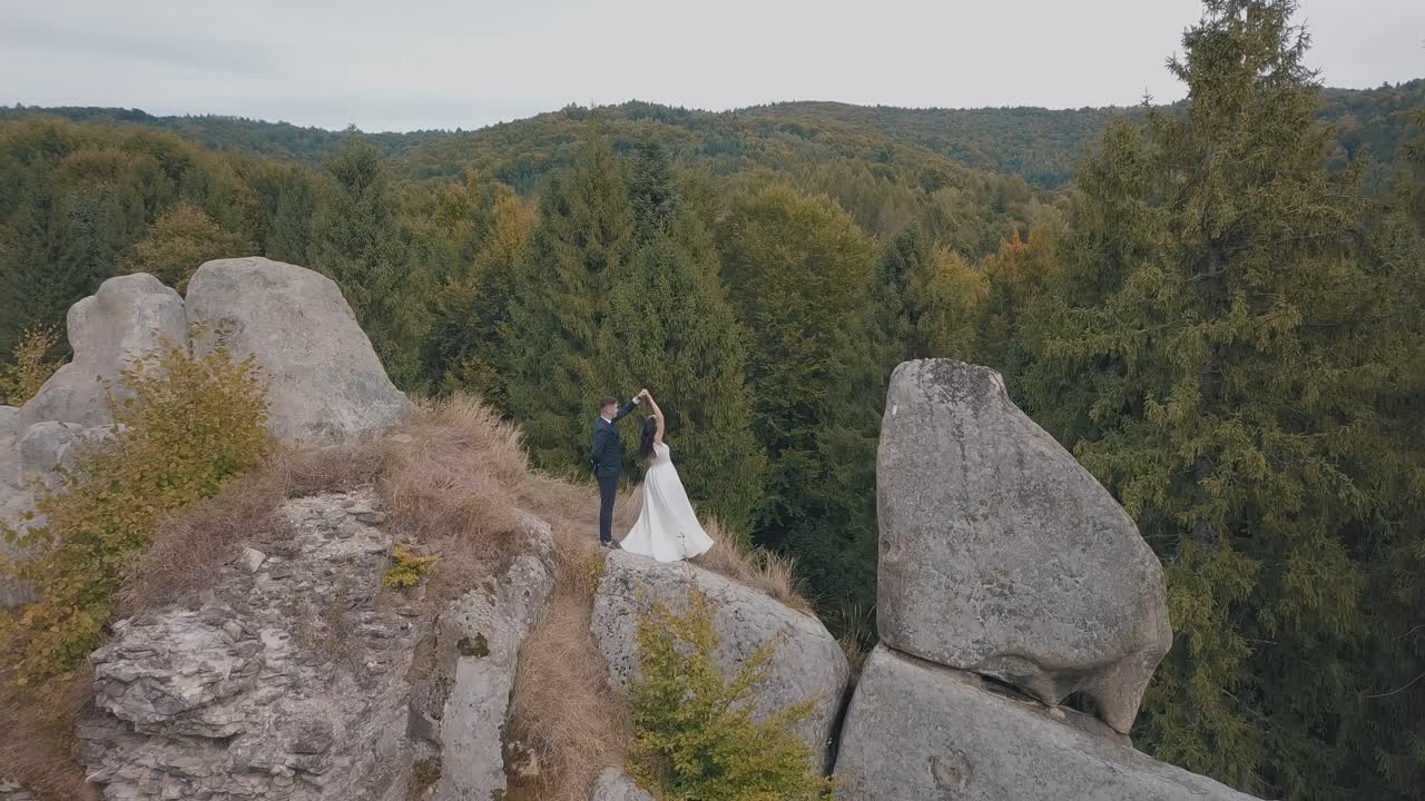 los recién casados están en una ladera alta de la montaña. el novio y la novia. vista aérea