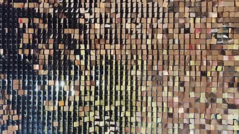 abstract background with flickering metallic or plastic particles wall, same size of shape of particles, real footage, a wall of golden sparkles spiked in the wind