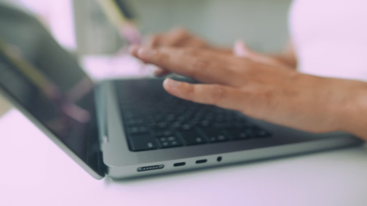 Primo piano di mani che digitano sulla tastiera di un portatile